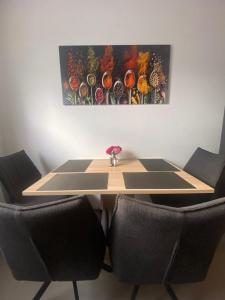 a table with two chairs and a painting on the wall at Wasserburg 1 I Familienfreundlich - Ruhig & Erdgeschoss I Parkplatz inkl in Paderborn +11 photos