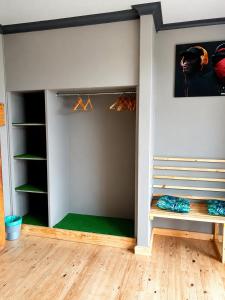 a room with a closet with hangers and a wall at Lungile Backpackers in Gqeberha