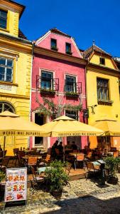 a restaurant with tables and umbrellas in front of a building at Casa Kuhn in Sighişoara