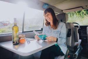 a woman sitting at a table in a van reading a book at Camper Hipalán in San Sebastián de la Gomera +8 photos
