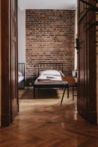 a bedroom with a bed and a brick wall at Hostel Kamienica 9 in Sosnowiec +8 photos