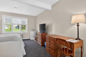 ein Schlafzimmer mit Schreibtisch, Bett und Fernseher in der Unterkunft Wilder Inn in Ephraim