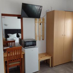 a room with a desk with a microwave and a tv on top at ANNA MARIA Studios in Potos