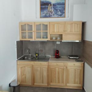 a kitchen with wooden cabinets and a sink at ANNA MARIA Studios in Potos