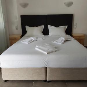 a large white bed with two towels on it at ANNA MARIA Studios in Potos