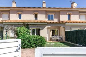 a house with a white fence in front of it at Casa con piscina comunitaria in L'Escala