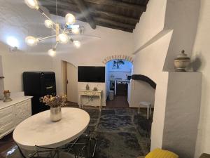 a living room with a white table and a kitchen at Sublime Village House in Monsaraz