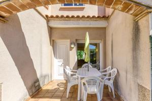 a patio with a white table and chairs at Casa con piscina comunitaria in L'Escala