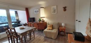 a living room with a table and a dining room at Cosy and nice view on mountains in Villard-de-Lans