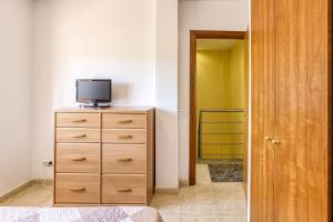 a bedroom with a dresser with a tv on top of it at Casa con piscina comunitaria in L'Escala