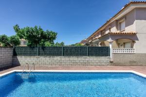 a swimming pool in front of a house at Casa con piscina comunitaria in L'Escala
