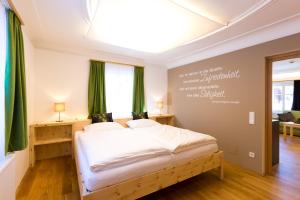 una camera da letto con un grande letto con tende verdi di himmlisch urlauben St. Nikolai a Sankt Nikolai im Sölktal