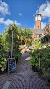 a garden with a sign on a brick walkway at De Gouden Cruytbusse in Middelburg