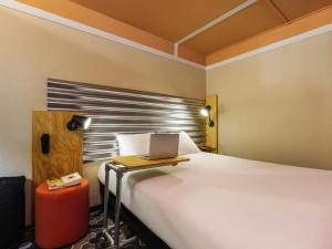 a bedroom with a bed with a laptop on it at Ibis Styles Bobigny Centre Préfecture in Bobigny +55 photos