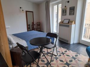 a bedroom with a bed and a table and chairs at Casa Morenica - Cementina in Montalto Dora