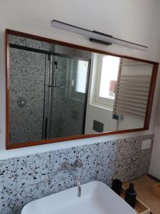 a mirror above a sink in a bathroom at Casa Morenica - Cementina in Montalto Dora