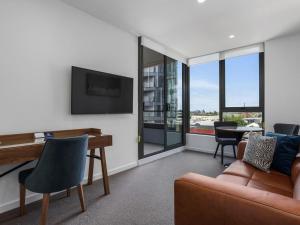 a living room with a couch and a desk at The Sebel Melbourne Moonee Ponds in Melbourne