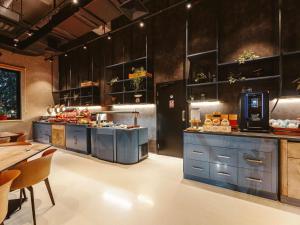 a large kitchen with blue cabinets and a table at ibis Tbilisi Stadium in Tbilisi City