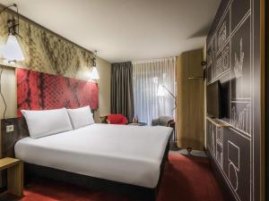 a hotel room with a large bed and a tv at ibis Tbilisi Stadium in Tbilisi City