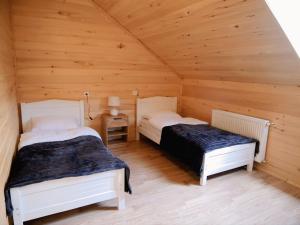 a bedroom with two beds in a wooden cabin at Gablile apartments in Mestia