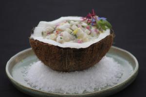 a coconut cut in half sitting on a plate at Hotel Spa Nau Royal in Camburi