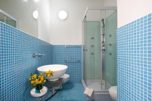 a bathroom with a sink and a shower with blue tiles at Residenze Uliveto - Rooms in Nardò +71 photos