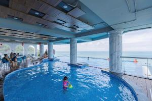 a little girl in a pool on a cruise ship at Oyster Bay Vũng Tàu - Seaside Pool Escape in Vung Tau