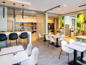 a restaurant with white tables and chairs at B&B HOTEL Wertheim in Wertheim
