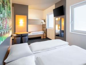 a bedroom with two beds and a bunk bed at B&B HOTEL Wertheim in Wertheim +16 photos