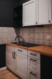 a kitchen with white cabinets and a sink at Hostel Kamienica 9 in Sosnowiec