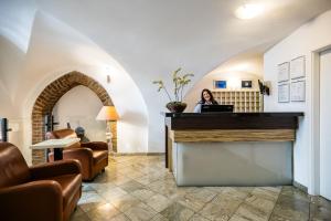 a woman sitting at a counter in a room with a laptop at Hotel Metamorphis in Prague