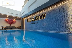 a swimming pool with a sign on the side of a building at Flexistay Sheikh Zayed in Sheikh Zayed