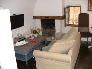 a living room with a couch and a table with a fireplace at La Suite du Village d'Eze in Éze