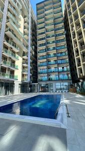 a swimming pool in front of two tall buildings at Aqua Batumi 47 in Batumi