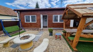a backyard with a playground and a house at HT Apartman in Mezőkövesd
