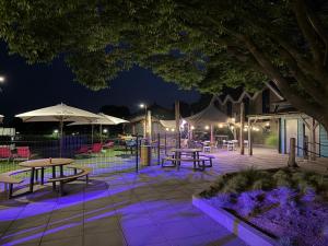 a patio with tables and umbrellas at night at FerienChalet-Icra in Lathum