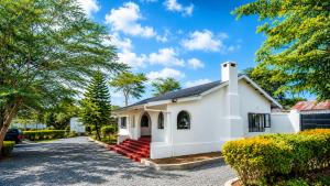 a small white house with a driveway at Naisula Home in Naivasha