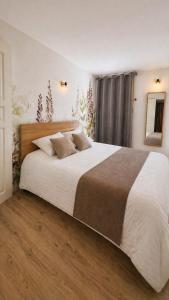a bedroom with a large bed with white sheets at Studio Cosy in Coussergues