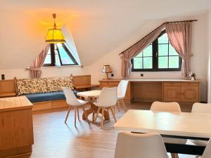 a living room with a couch and tables and chairs at In & Out Boardinghaus in Stolberg
