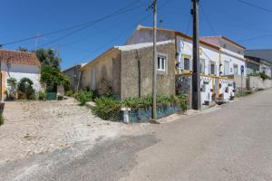 an empty street in a small town with buildings at Casinha Peral Country Cottage in Peral