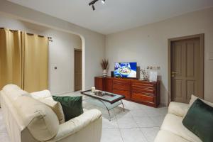 a living room with two white couches and a tv at Savoy Signature Stays in Il-Gżira +24 photos