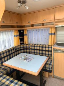a living room with a couch and a table at Hobby De Luxe Caravan in Copenhagen