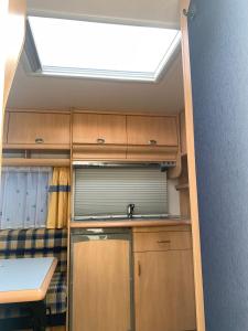 a small kitchen with a sink and a skylight at Hobby De Luxe Caravan in Copenhagen