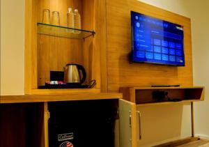a kitchen with a tv and a black refrigerator at Hotel Fortune Plaza in Karnal