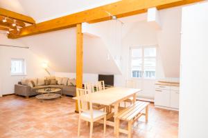 cocina y sala de estar con mesa de madera y sillas en Villa Elise, en Bad Schandau