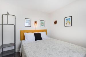 a white bedroom with a bed with a orange headboard at Casinha Peral Country Cottage in Peral