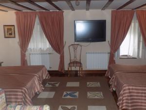 a hotel room with two beds and a flat screen tv at Itsasmin Ostatua in Elanchove