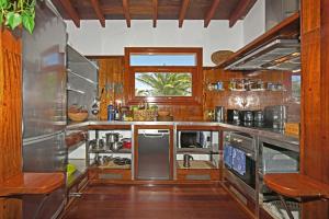 a large kitchen with wooden floors and stainless steel appliances at Casa Simbad in Pájara