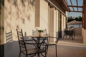 a patio with chairs and a table with a plant on it at JUNO Collection Residences in Pythagoreio