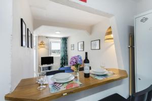 a dining room with a table with a bottle of wine at Casinha Peral Country Cottage in Peral